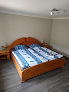 1 dormitorio con cama de madera y manta azul en Haus Sperling en Bad Zwischenahn