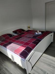 Bett in einem Zimmer mit einer karierten Matratze in der Unterkunft Haus Sperling in Bad Zwischenahn