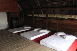 three bunk beds in a room with wooden floors at SONY COTTAGE in Tuk Tuk