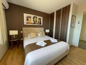 1 dormitorio con 1 cama grande y 2 toallas. en YVES SAINT LAURENT/ COCO CHANEL en Albi