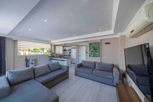 een woonkamer met 2 banken en een flatscreen-tv bij Comfort-design-peace of mind in Fethiye