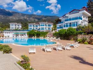 a resort with a swimming pool and lounge chairs at Comfort-design-peace of mind in Fethiye