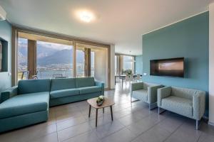 een woonkamer met een bank en stoelen en een tv bij Bellagio Village- 4 Apartments by the lake - Seasonal Warm Pool and Sauna in Oliveto Lario +36 foto's