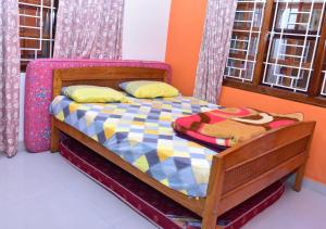 um quarto com uma cama de madeira num quarto com janelas em Sri Kaveri Homestay em Madikeri