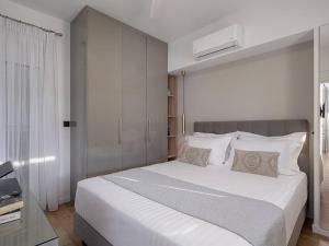 a bedroom with a large white bed with white pillows at Marita Luxury Apartment with parking space in Chania