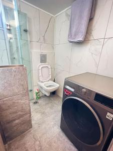 a bathroom with a washing machine and a toilet at Minimal 3BR Apartment in Athens in Athens