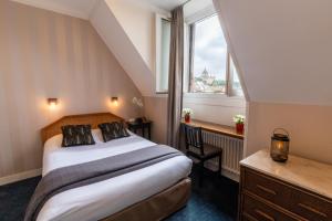 a hotel room with a bed and a window at L'Hotel De L'Esperance in Lisieux