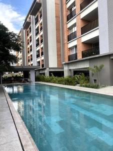 a large blue swimming pool in front of a building at apartamento (de) Linda in Puerto Vallarta