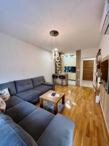 sala de estar con sofá azul y mesa en Apartman Lux Doboj 2, en Doboj