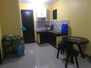 una cucina con lavandino, tavolo e sgabello di Affordable Whole House Rent Transient a Butuan
