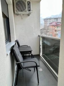 un balcón con 2 sillas y una mesa en un edificio en Apartman Lux Doboj 2, en Doboj