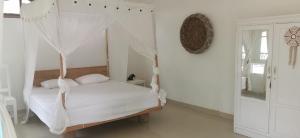 a bedroom with a bed with a mosquito net at the village rua beach homestay in Rua