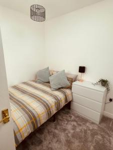 a small bedroom with a bed and a night stand at Stylish, Comfortable Coach House in Falmouth