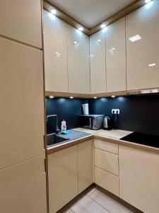 cocina con armarios blancos y microondas en Apartman Lux Doboj 2, en Doboj