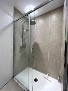 La salle de bains est pourvue d'une douche avec une porte en verre. dans l'établissement Tendance - Centre Montereau, à Montereau-faut-Yonne