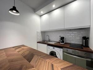 - une cuisine avec des placards blancs et un lave-linge dans l'établissement Tendance - Centre Montereau, à Montereau-faut-Yonne