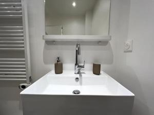 La salle de bains est pourvue d'un lavabo blanc et d'un robinet. dans l'établissement Tendance - Centre Montereau, à Montereau-faut-Yonne