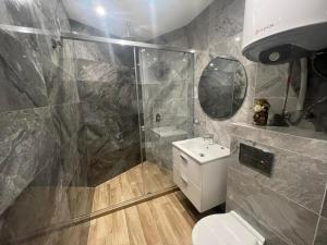 een badkamer met een douche, een toilet en een wastafel bij Apartments Mir Varna city in Varna