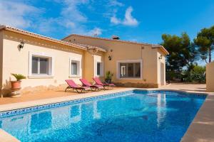 a villa with a swimming pool in front of a house at Villa Amelia - PlusHolidays in Ifach