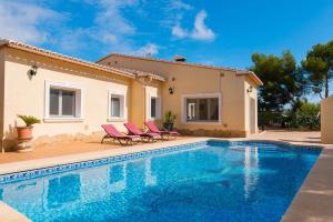 a villa with a swimming pool in front of a house at Villa Amelia - PlusHolidays in Calpe