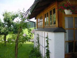 Una pequeña casa con una ventana y flores. en Appartement Schelhas, en Prien am Chiemsee