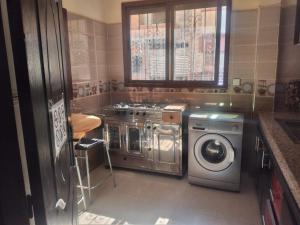a kitchen with a stove and a washing machine at Mohammed V Airport RAHMANI in Deroua