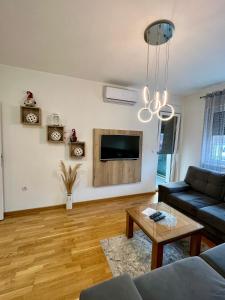 sala de estar con sofá y TV en la pared en Apartman Lux Doboj 2, en Doboj