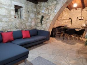 sala de estar con sofá azul y pared de piedra en Galileo Cottage House (BREAKBOOKING CY), en Parekklisha