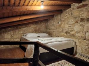 Habitación con cama en una pared de piedra. en Galileo Cottage House (BREAKBOOKING CY), en Parekklisha