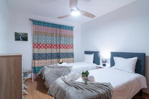 a bedroom with two beds and a quilt on the wall at Island Jewel in Vila Franca do Campo