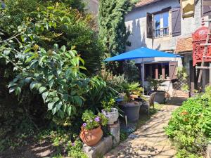 Arthez-de-BéarnにあるLe Chat Botté Chambres et Table d'hôte sur réservationの植物と青傘が植えられた庭園