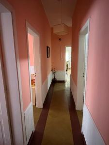 un pasillo vacío con paredes rosas y puertas blancas en Alojamiento en La Falda - MSL en La Falda