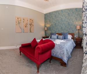 a bedroom with a bed and a red chair at Beaumont Windermere - Adults-Only Boutique Guest House- Free Parking & Wellness Access in Windermere +71 photos