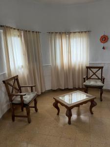 salon z 2 krzesłami i stolikiem kawowym w obiekcie Alojamiento en La Falda - MSL w mieście La Falda