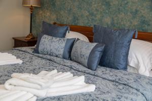 Una cama con dos toallas blancas encima. en Beaumont Guest House - FREE off-site Health Club - Adults Only en Windermere