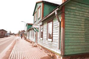 eine Reihe von Holzgebäuden an der Straßenseite in der Unterkunft Kantreküla Apartment in Viljandi