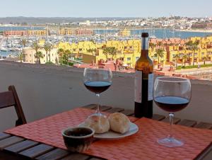 a table with two glasses of wine and a bottle at Flat Vista RioMar by Francisco in Portimão