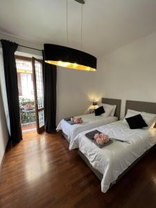 ローマにあるEMI's Guest Houseのベッドルーム1室(花の飾られたベッド2台付)
