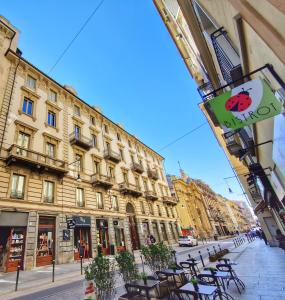 uma rua com mesas e cadeiras em frente aos edifícios em Ana's Place Torino 2 em Turim