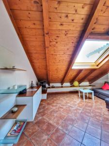 ein Wohnzimmer im Dachgeschoss mit Holzdecke in der Unterkunft Ana's Place Torino 2 in Turin