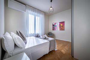 een witte slaapkamer met een groot bed en een raam bij YiD Cairoli design apartment in Florence