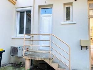 eine Treppe, die zu einer Tür eines Hauses führt in der Unterkunft Appartement plein centre in Paray-le-Monial