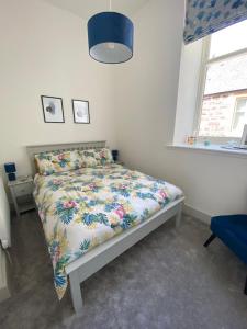 - une chambre avec un lit et une couette à fleurs dans l'établissement Premium apartment in a peaceful location with great views., à Inverness