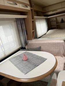 a table in an rv with a room with two beds at Leihwohnwagen Camping-Aach in Oberstaufen