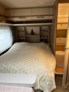 Dormitorio pequeño con cama y algunos armarios en Leihwohnwagen Camping-Aach, en Oberstaufen