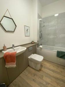 uma casa de banho com um lavatório, um WC e uma banheira em Premium apartment in a peaceful location with great views. em Inverness