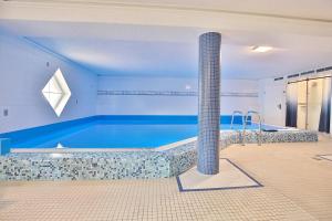 a blue room with a swimming pool with a pillar at Residenz Ostseestrand Appartement 26 in Scharbeutz