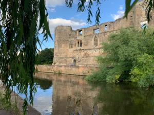 an old castle sitting next to a river at Poppy Annex in Wellow