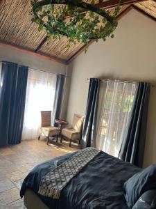 een slaapkamer met een bed in een kamer met ramen bij JUMANJI NATURE RESORT in Hartbeespoort