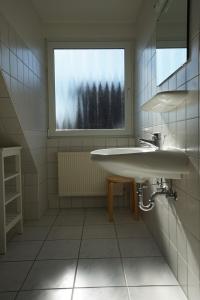 La salle de bains est pourvue d'un lavabo et d'une fenêtre. dans l'établissement Klabautermann Wohnung 6 3, à Büsum
